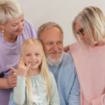 A joyful multigenerational family poses and smiles together indoors, showcasing love and togetherness.