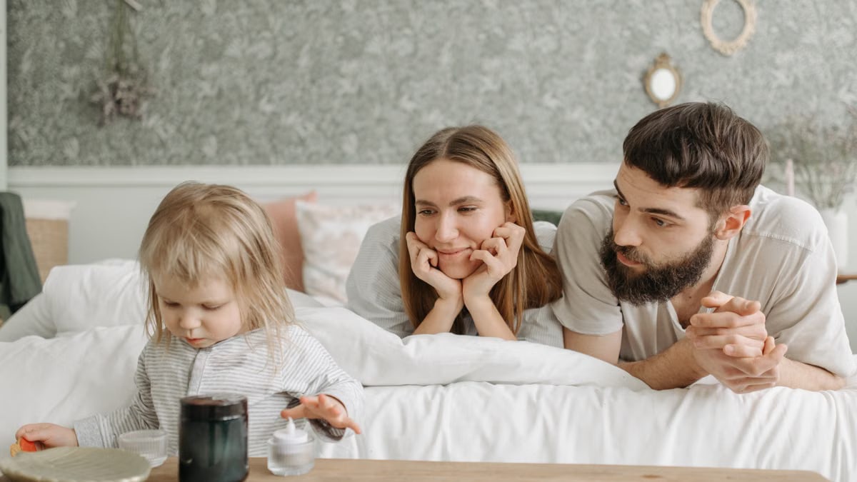 A loving family of three enjoying time together in a peaceful bedroom setting.